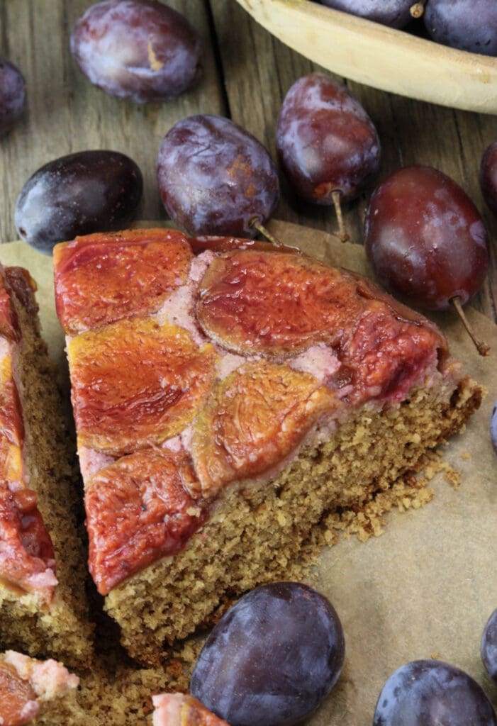 A slice of plum cake by a traditional plum upside down cake recipe.